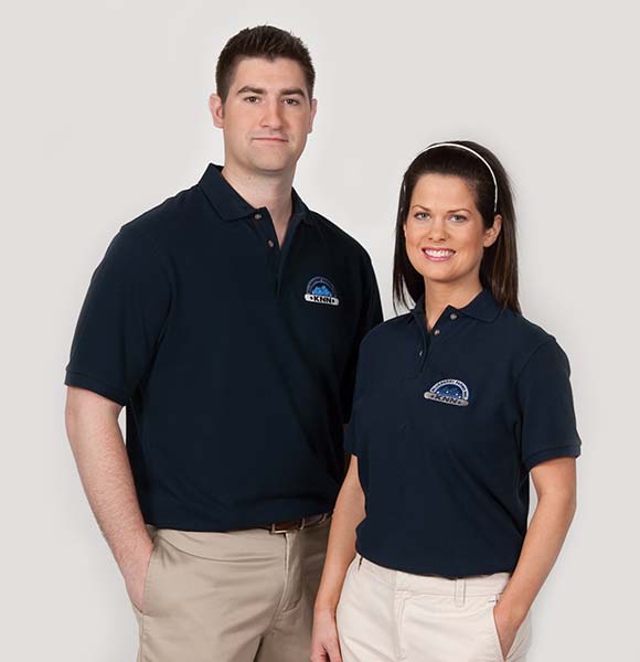 Man & Woman wearing logo'd polo uniforms